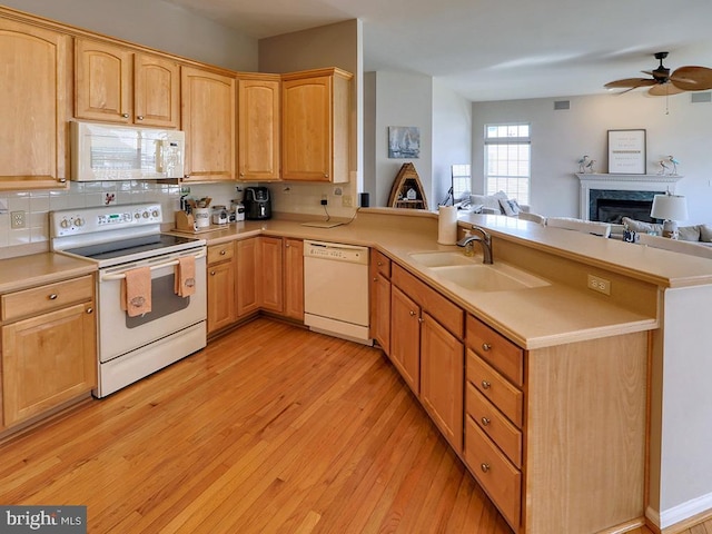 kitchen with white appliances, kitchen peninsula, tasteful backsplash, and sink