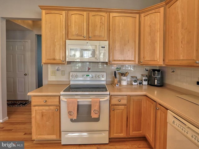 kitchen with white appliances, tasteful backsplash, and light hardwood / wood-style floors