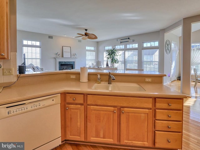 kitchen featuring kitchen peninsula, light wood-type flooring, white dishwasher, ceiling fan, and sink