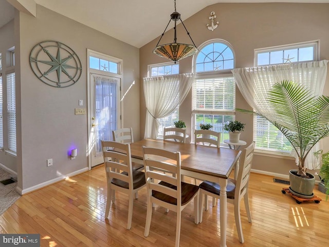 dining area featuring lofted ceiling, light wood-type flooring, and plenty of natural light