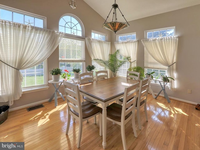 dining room with vaulted ceiling and light hardwood / wood-style floors