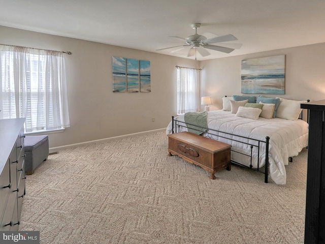 bedroom featuring ceiling fan, light carpet, and multiple windows