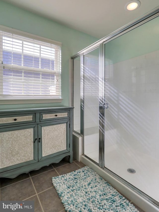 bathroom featuring walk in shower and tile patterned flooring