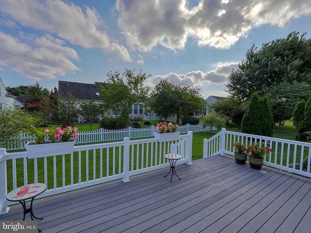 wooden deck featuring a lawn