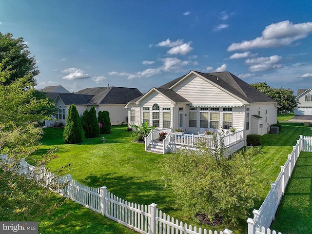 rear view of house with a yard and a wooden deck