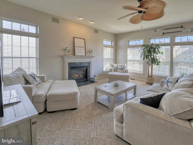 carpeted living room featuring ceiling fan and a fireplace