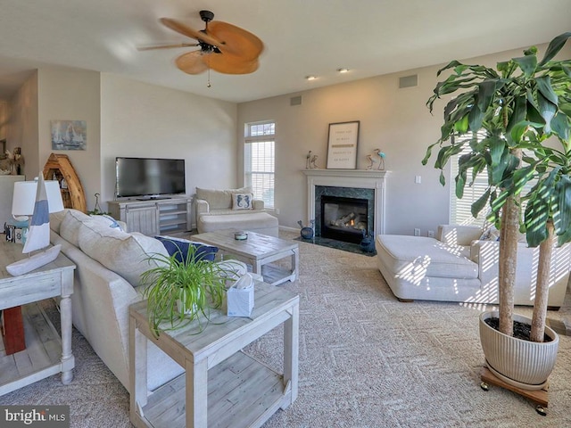 living room featuring a fireplace and ceiling fan