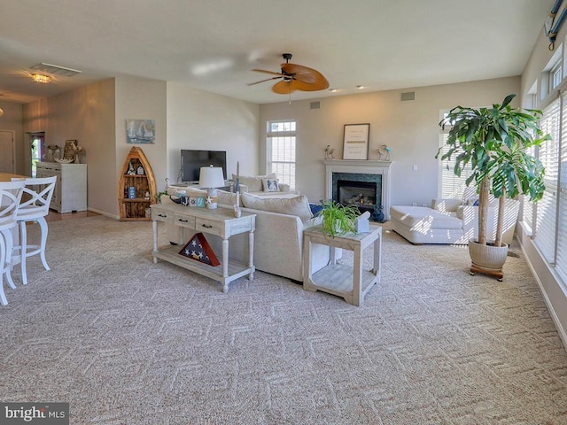 living room featuring ceiling fan, light carpet, and plenty of natural light