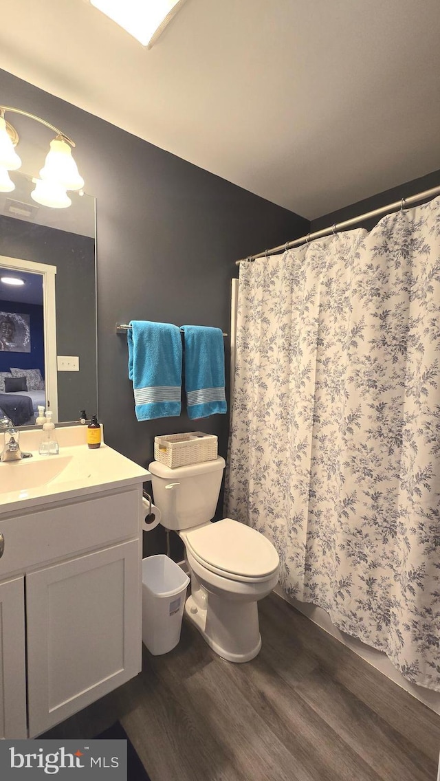 bathroom featuring toilet, vanity, and hardwood / wood-style flooring