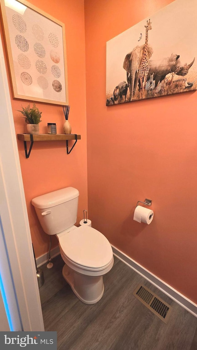 bathroom with hardwood / wood-style floors and toilet