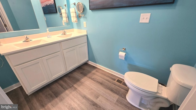 bathroom featuring hardwood / wood-style floors, vanity, and toilet