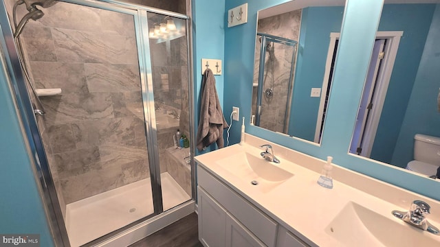 bathroom featuring walk in shower, hardwood / wood-style floors, vanity, and toilet