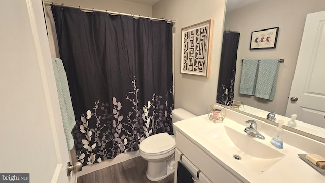 bathroom featuring wood-type flooring, vanity, and toilet