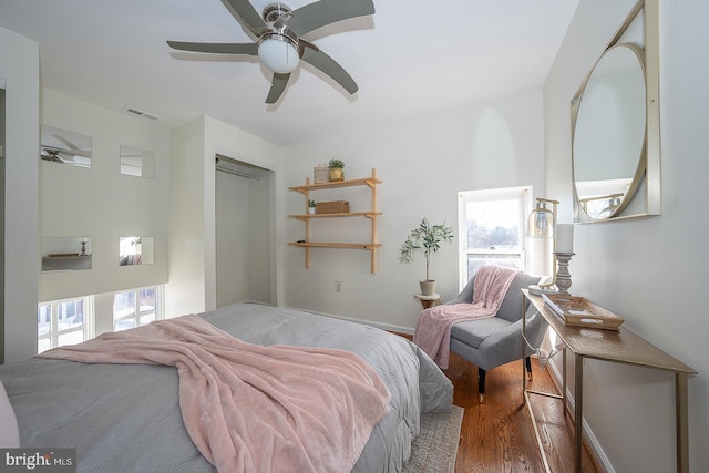 bedroom featuring hardwood / wood-style flooring, ceiling fan, a closet, and multiple windows