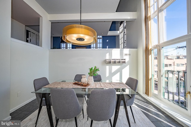 dining area with tile patterned floors and a towering ceiling