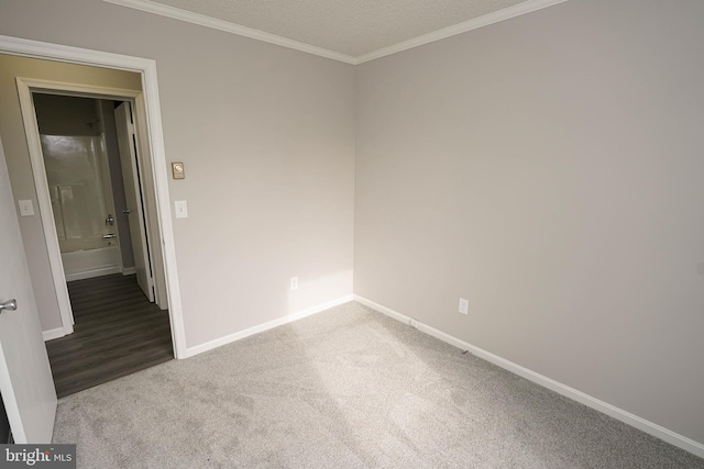 carpeted empty room featuring a textured ceiling and ornamental molding