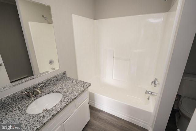 full bathroom featuring bathtub / shower combination, wood-type flooring, vanity, and toilet