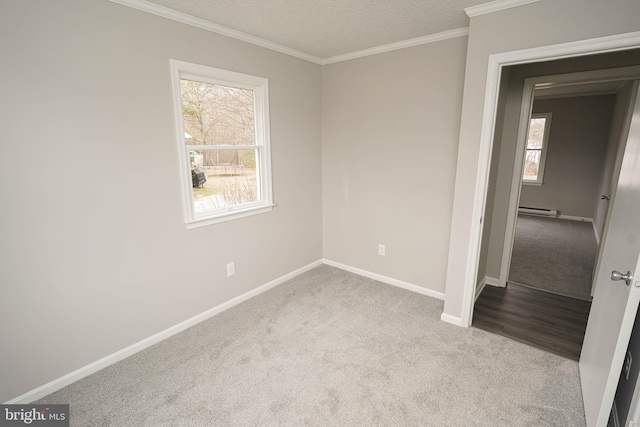 carpeted spare room featuring crown molding, a textured ceiling, and a baseboard heating unit