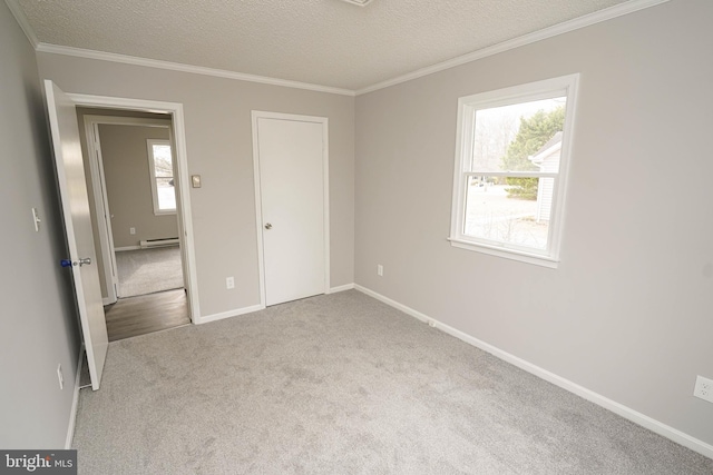 unfurnished bedroom with baseboard heating, multiple windows, light carpet, and a textured ceiling