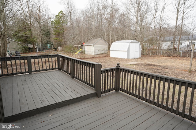 wooden terrace featuring a trampoline and a shed