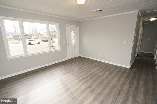 interior space featuring dark hardwood / wood-style flooring, a textured ceiling, and ornamental molding