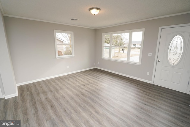 entryway featuring a textured ceiling, hardwood / wood-style flooring, and ornamental molding