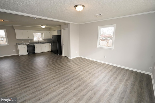 unfurnished living room featuring a textured ceiling, plenty of natural light, ornamental molding, and sink