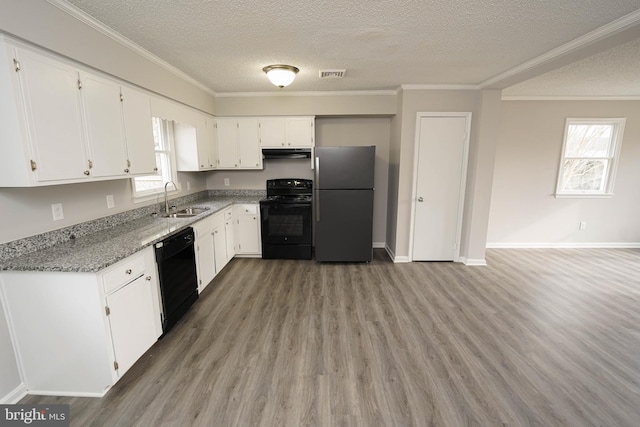 kitchen with black appliances, sink, light stone countertops, plenty of natural light, and white cabinetry