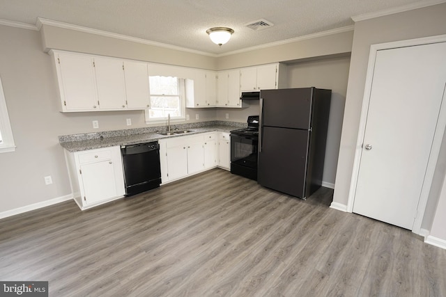 kitchen featuring sink, white cabinets, black appliances, and a textured ceiling