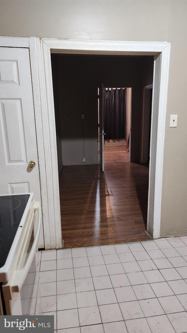 interior space featuring light tile patterned flooring and white electric range oven