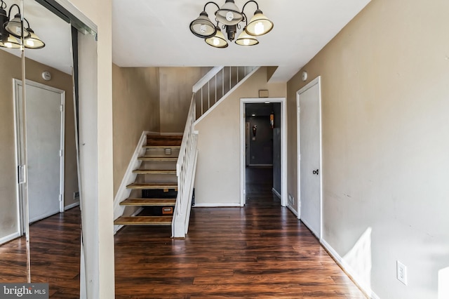 staircase featuring hardwood / wood-style flooring and an inviting chandelier