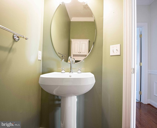 bathroom with hardwood / wood-style flooring and crown molding