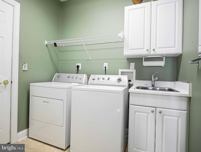 laundry room featuring cabinets, separate washer and dryer, and sink