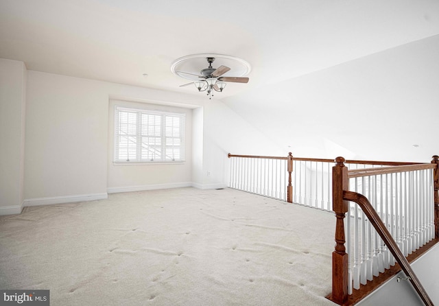 carpeted spare room featuring ceiling fan and lofted ceiling