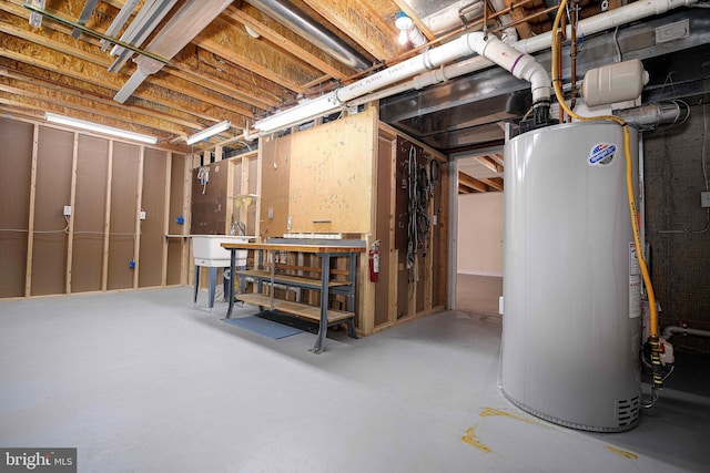 basement featuring a workshop area, sink, and gas water heater