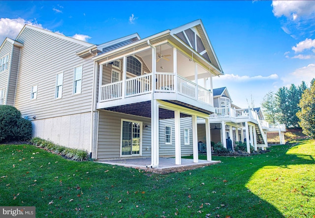 rear view of property featuring a yard, ceiling fan, and a patio area