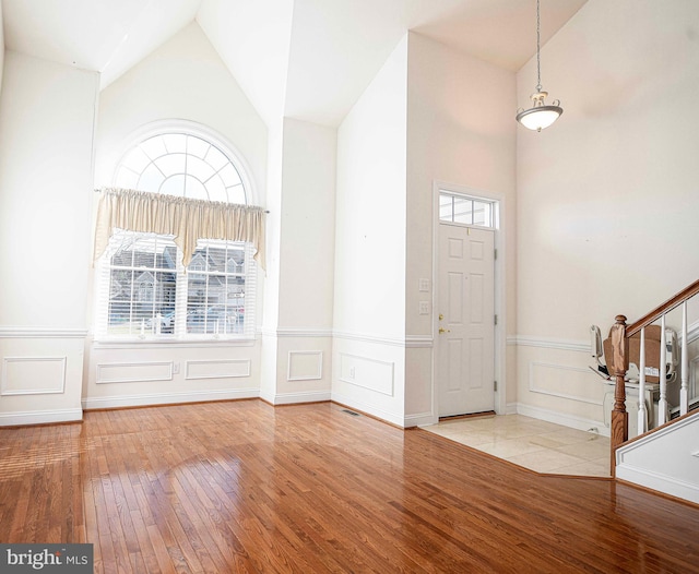 foyer entrance featuring plenty of natural light, light wood-type flooring, and vaulted ceiling