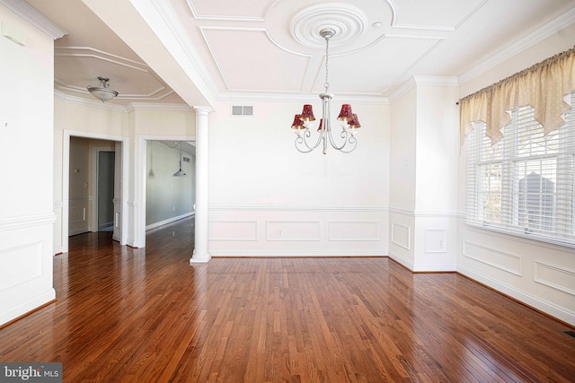 spare room with a chandelier, decorative columns, and dark wood-type flooring