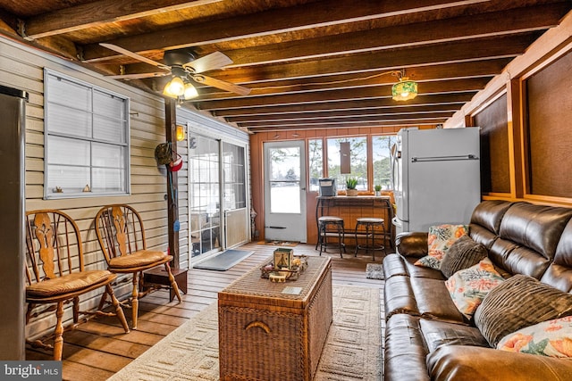 sunroom / solarium featuring ceiling fan, beam ceiling, and wooden ceiling