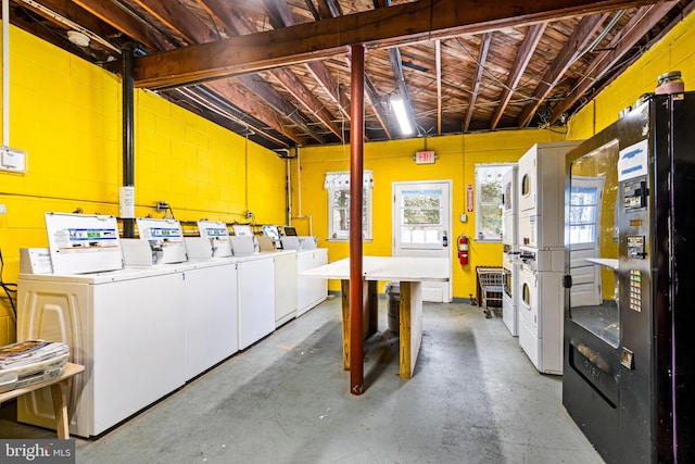 interior space featuring black fridge and stacked washer and clothes dryer