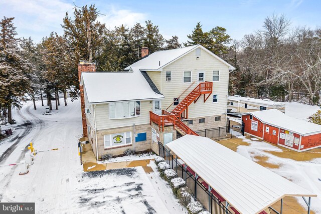 view of snow covered back of property