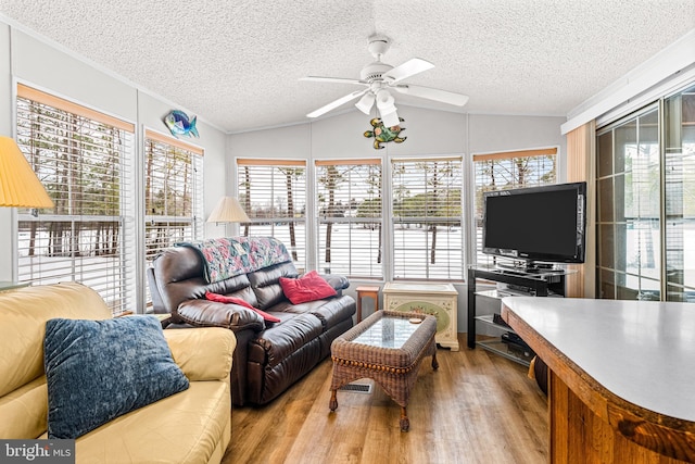 living room featuring ceiling fan, lofted ceiling, a textured ceiling, and light hardwood / wood-style flooring