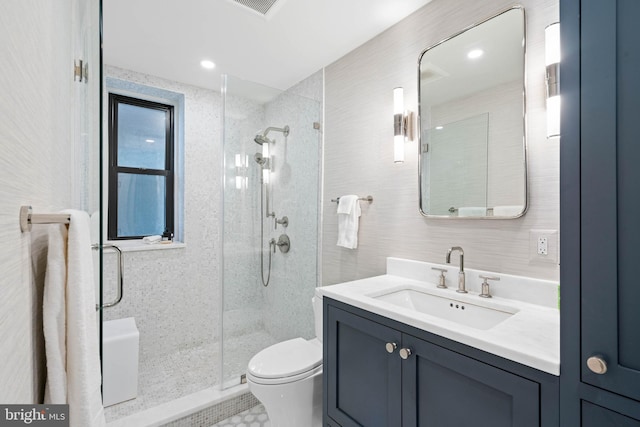 bathroom with vanity, toilet, and a shower with door