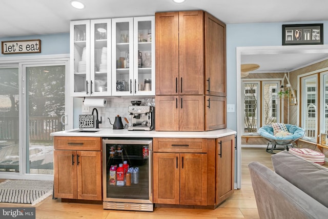 bar with decorative backsplash, beverage cooler, and sink