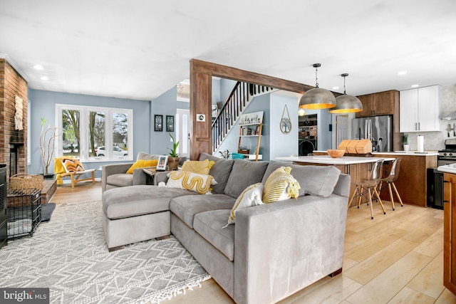 living room with light wood-type flooring and lofted ceiling