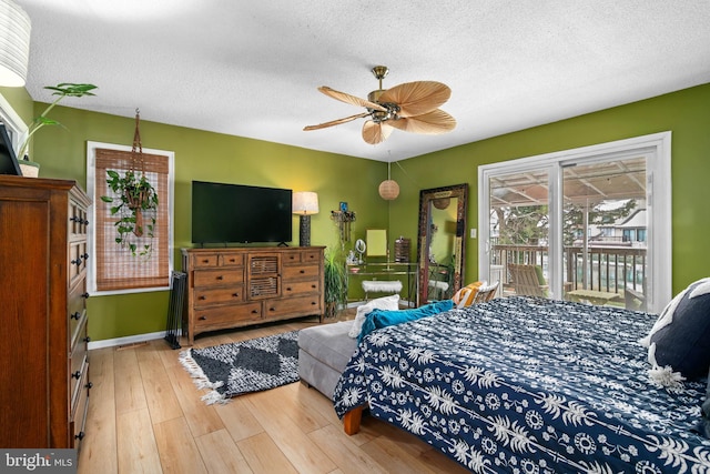 bedroom with a textured ceiling, ceiling fan, access to exterior, and hardwood / wood-style floors