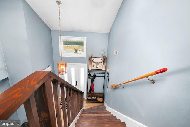 stairs with vaulted ceiling and hardwood / wood-style floors