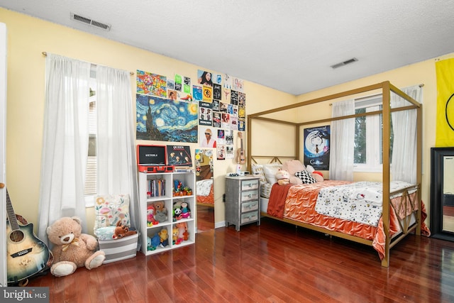 bedroom with wood-type flooring and a textured ceiling