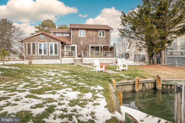 snow covered property with a wooden deck and a lawn