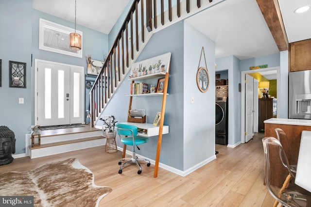 entryway featuring beam ceiling, washer / clothes dryer, and light wood-type flooring